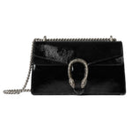 Black leather handbag with chain strap on a light gray background