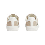 White sneakers with beige soles on a light gray background