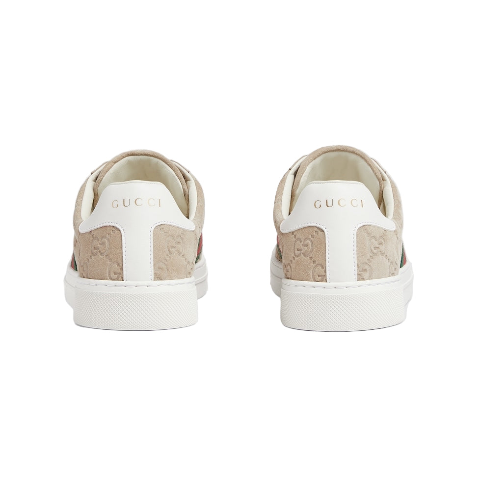 White sneakers with beige soles on a light gray background