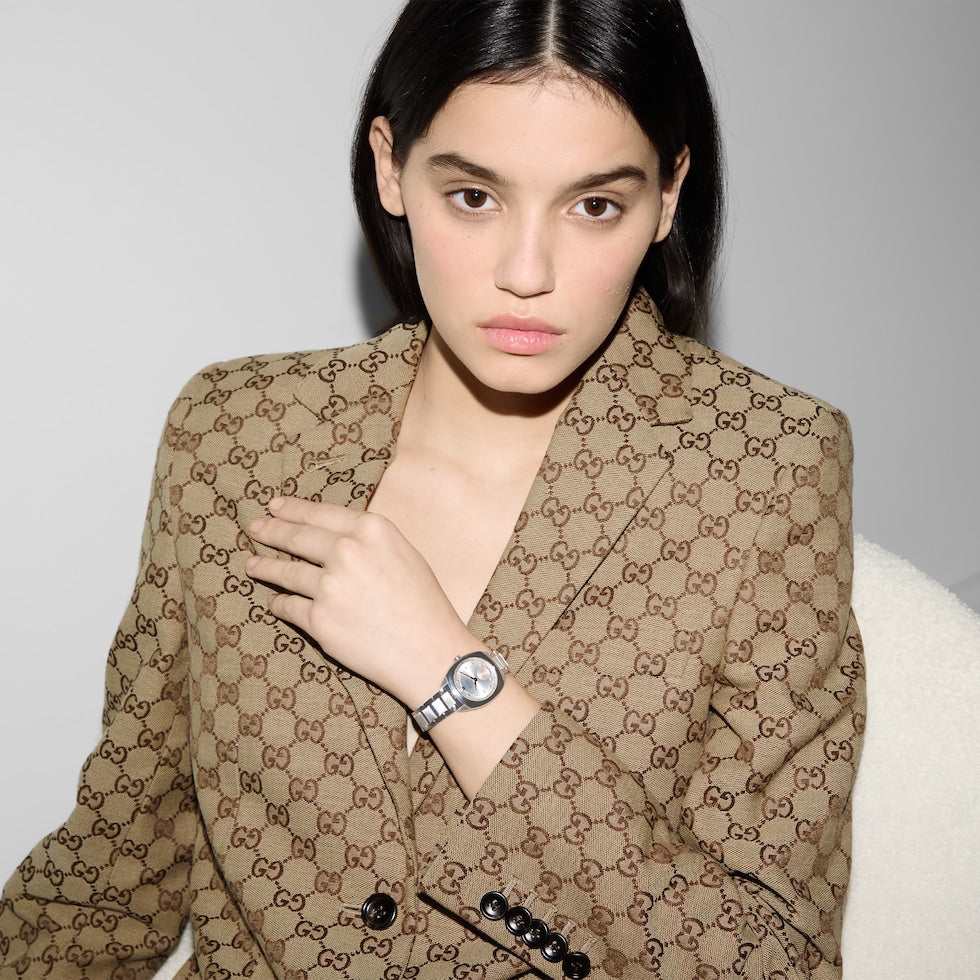 Woman wearing a patterned coat with a neutral background