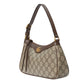 Designer handbag with brown and beige pattern on a light gray background