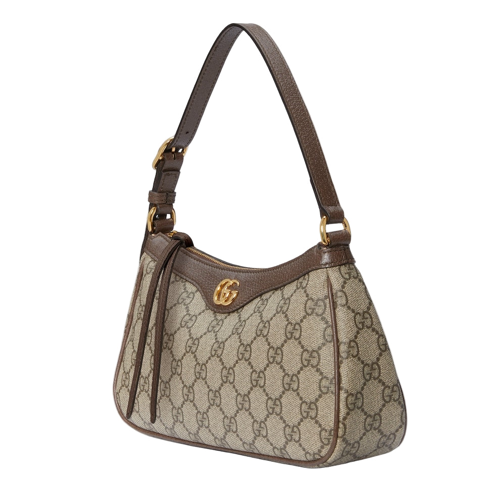 Designer handbag with brown and beige pattern on a light gray background
