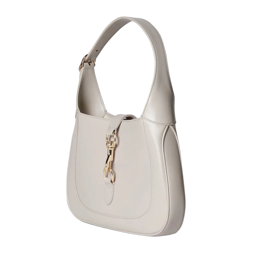 Beige handbag with a gold zipper on a light gray background