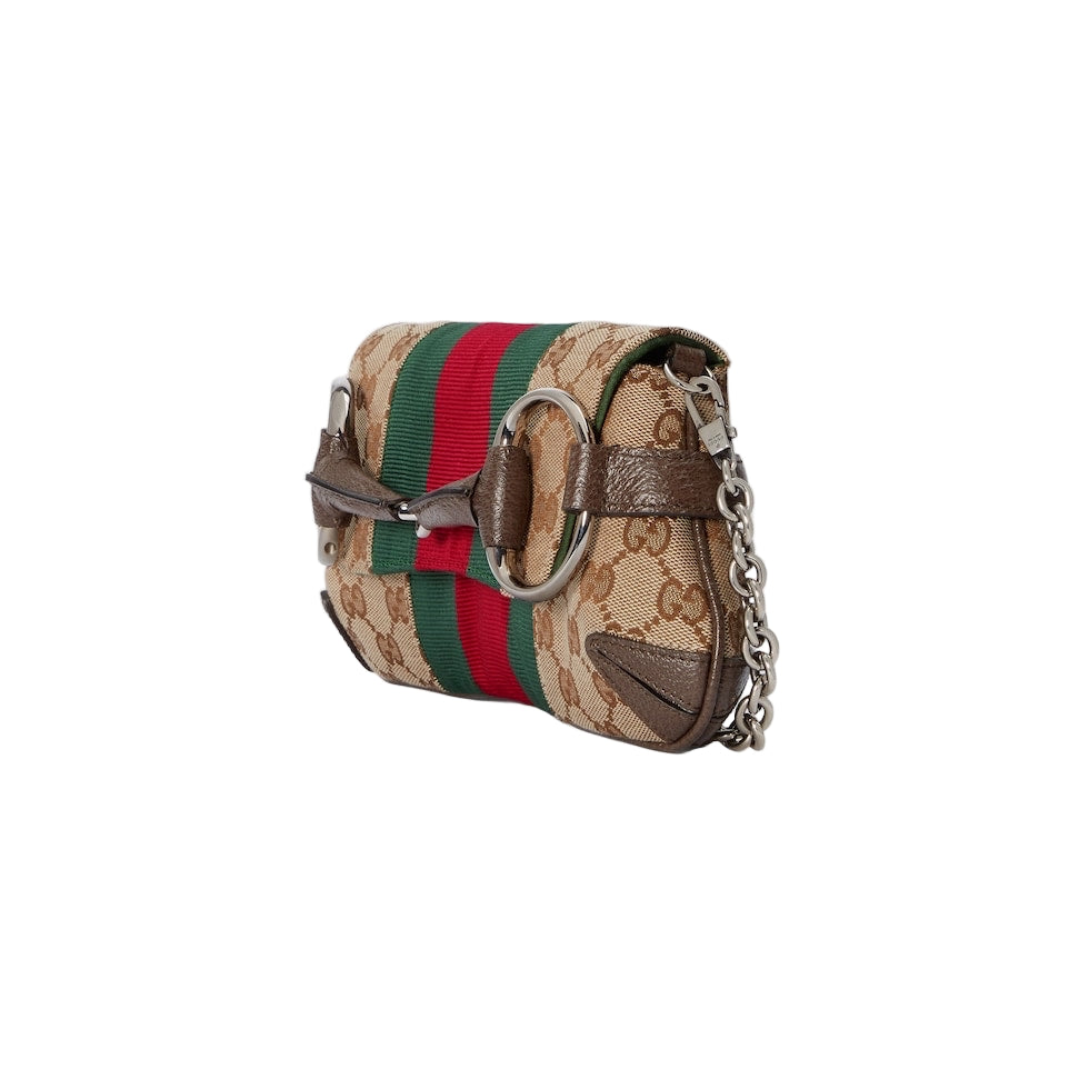 Designer handbag with Gucci logo and red and green stripes on a light gray background