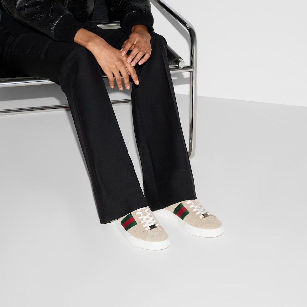 Person wearing Gucci sneakers with a white background