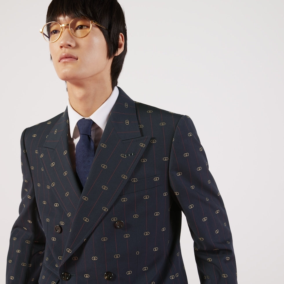 Man wearing a patterned suit and tie on a white background