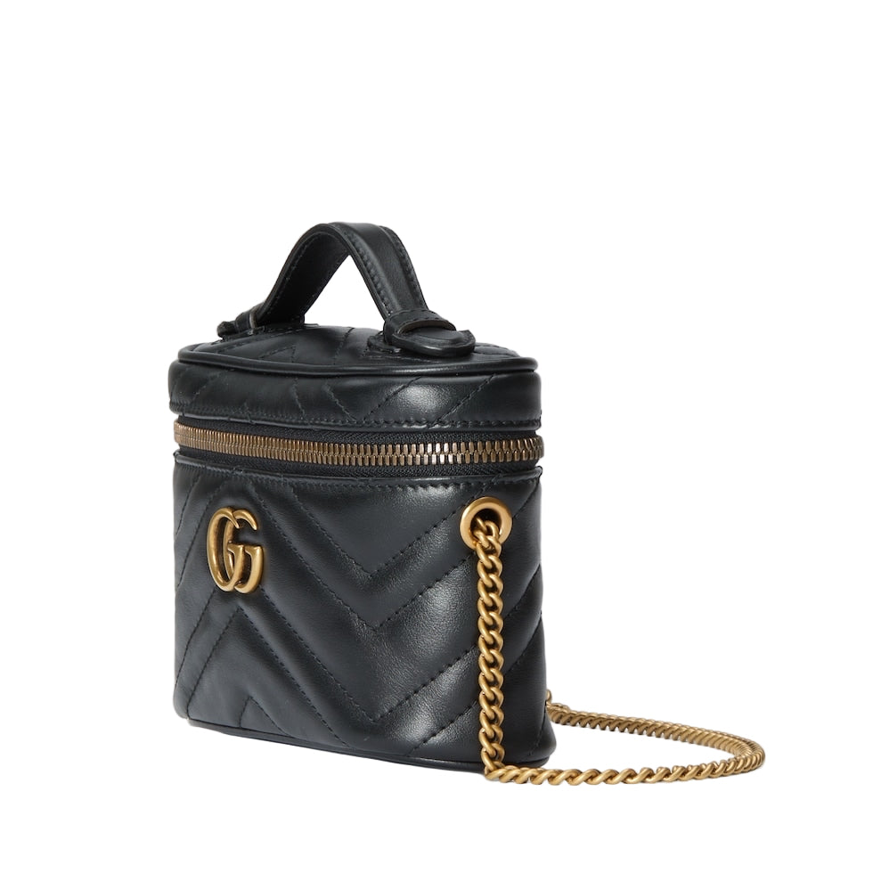 Black quilted handbag with gold chain and logo on a light gray background