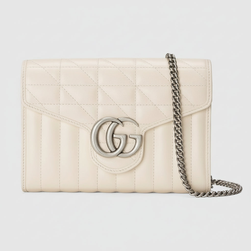 Cream-colored quilted handbag with chain strap on a light gray background