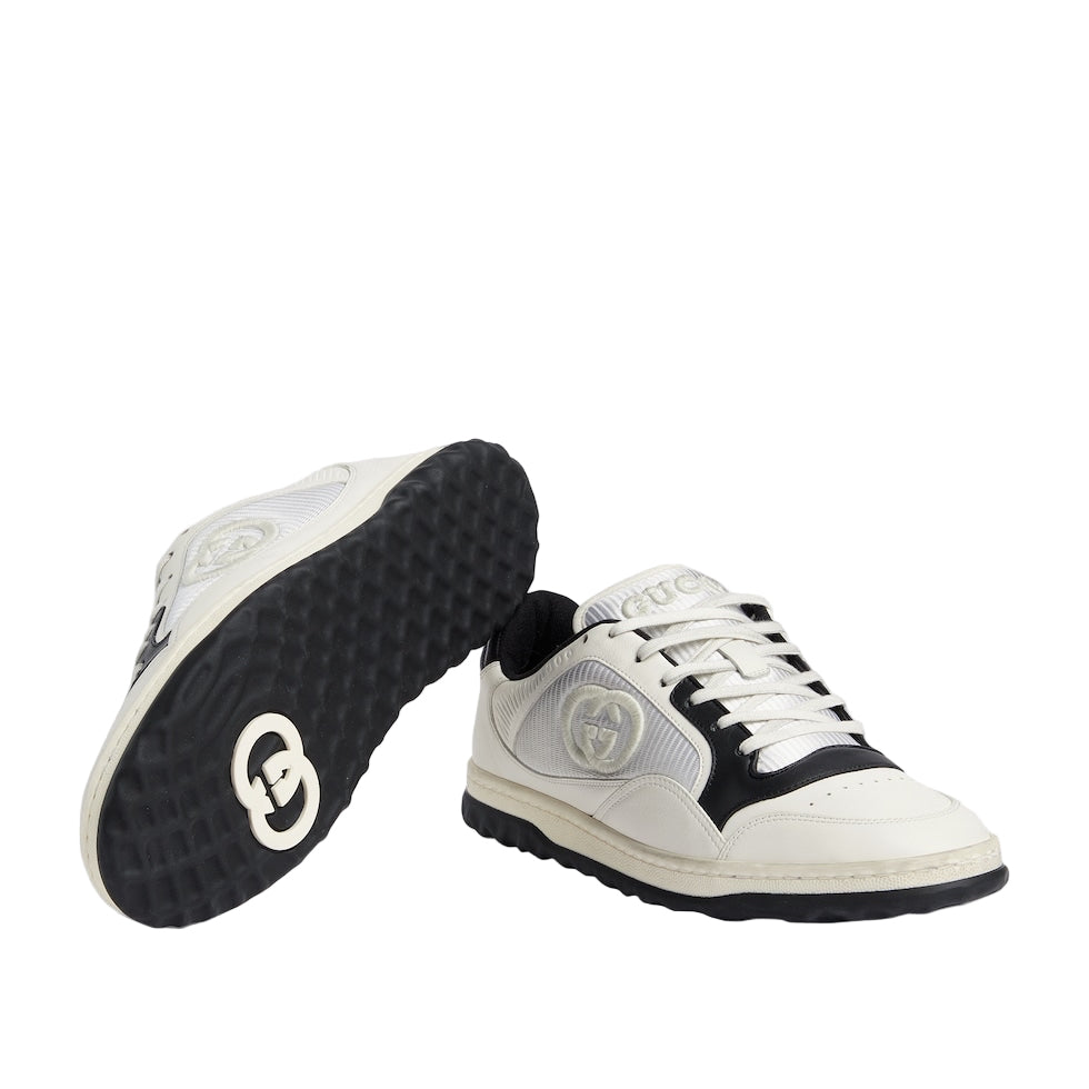 White sneakers with black soles on a light gray background