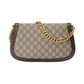 Designer handbag with gold chain strap on a light gray background