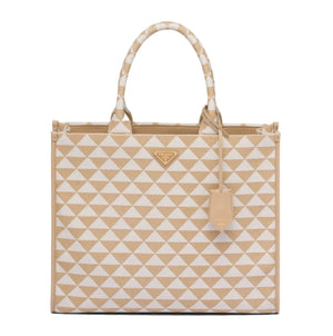 Prada tote bag featuring a beige and white geometric triangle pattern, with a small gold-tone Prada logo plaque on the front and a matching leather hangtag.