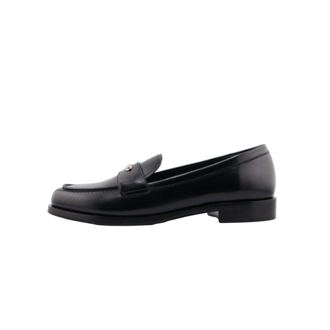 Black loafer shoe on a white cushioned surface