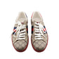 Pair of Gucci sneakers with distinctive pattern and red soles on a white background