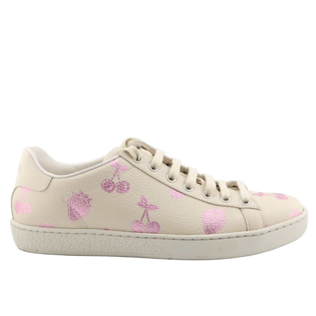 Beige Gucci sneaker with pink floral patterns on a white background
