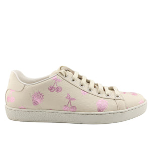 Beige Gucci sneaker with pink floral patterns on a white background