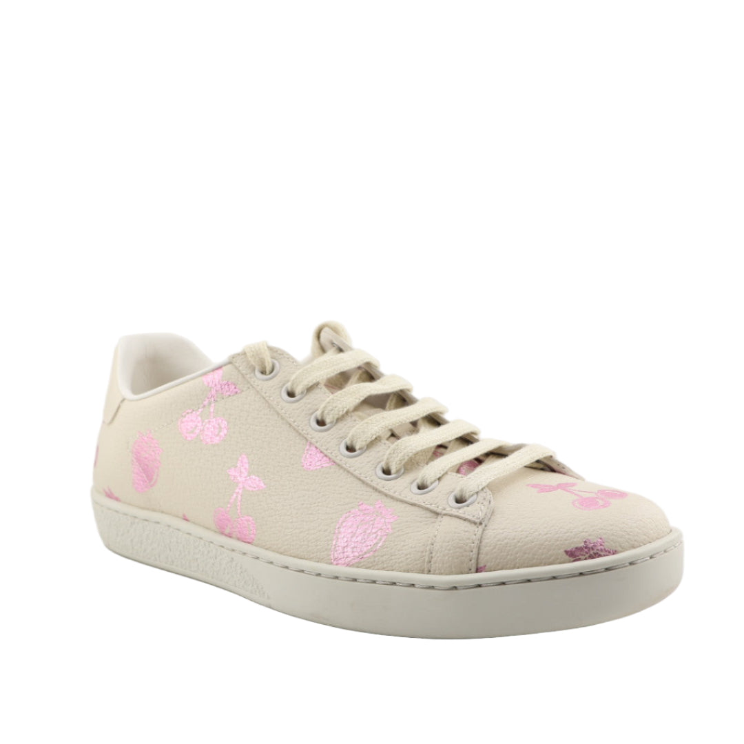 Beige sneaker with pink floral patterns on a white background