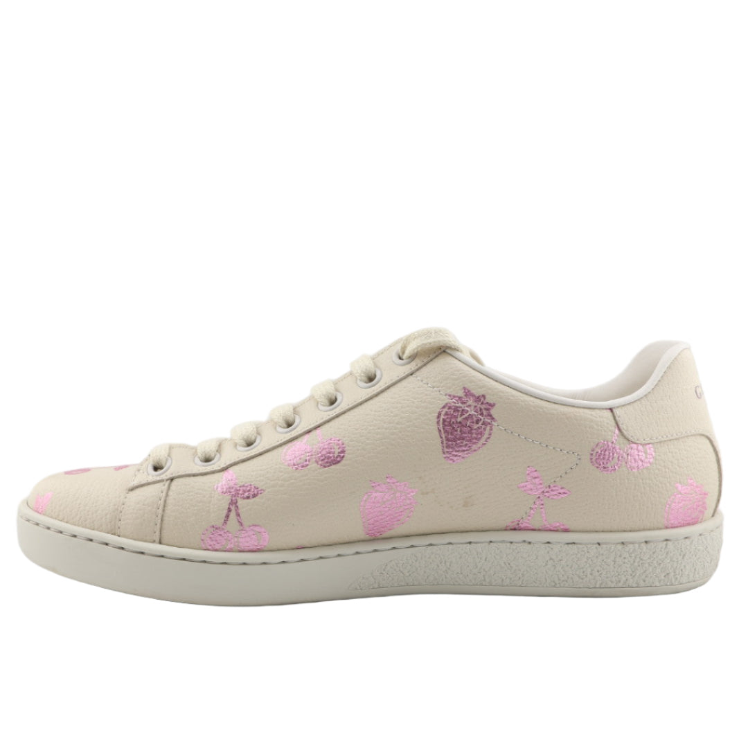 Beige sneakers with pink floral patterns on a white background