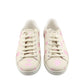 Pair of white sneakers with pink floral pattern on a white background