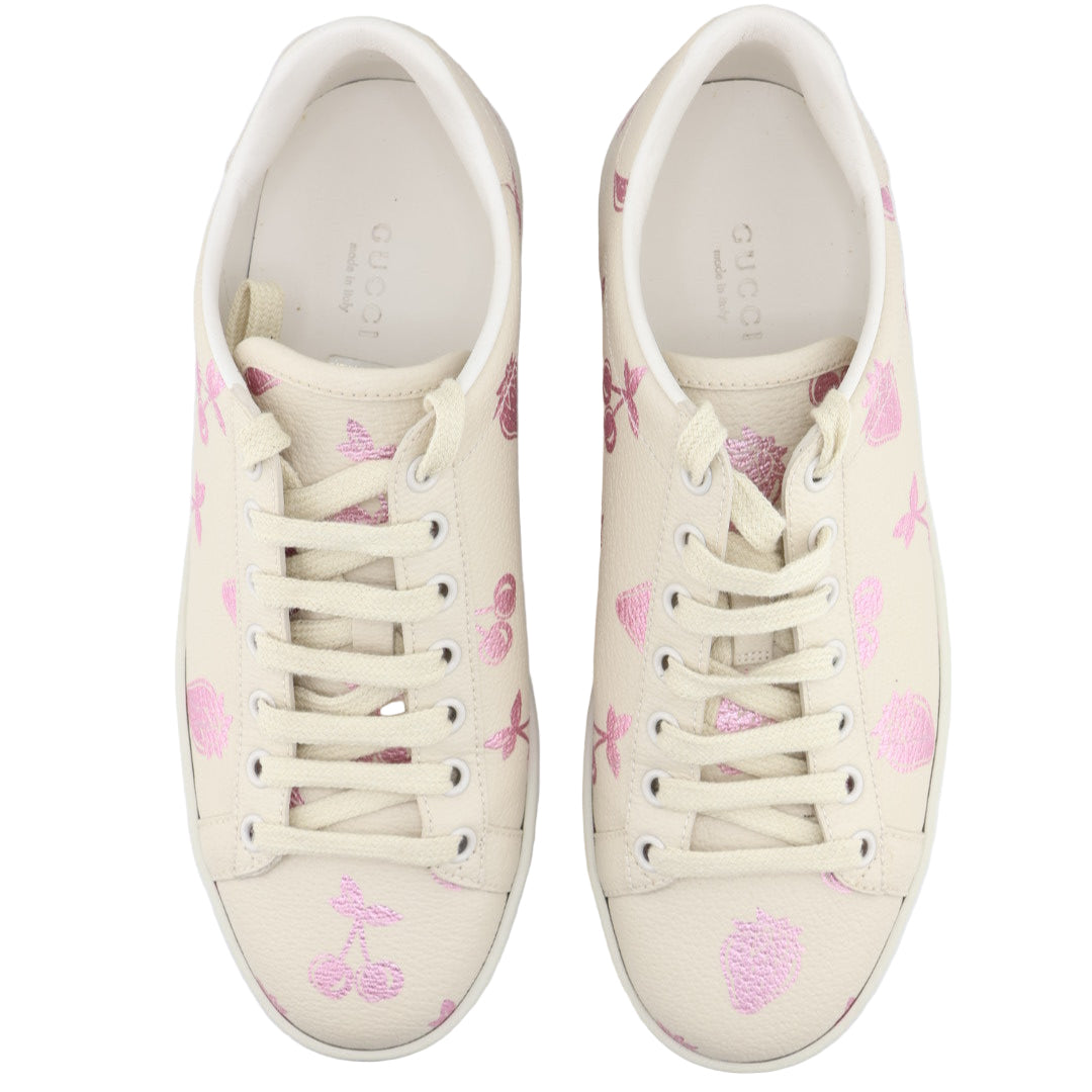 Pair of white sneakers with pink floral patterns on a white background
