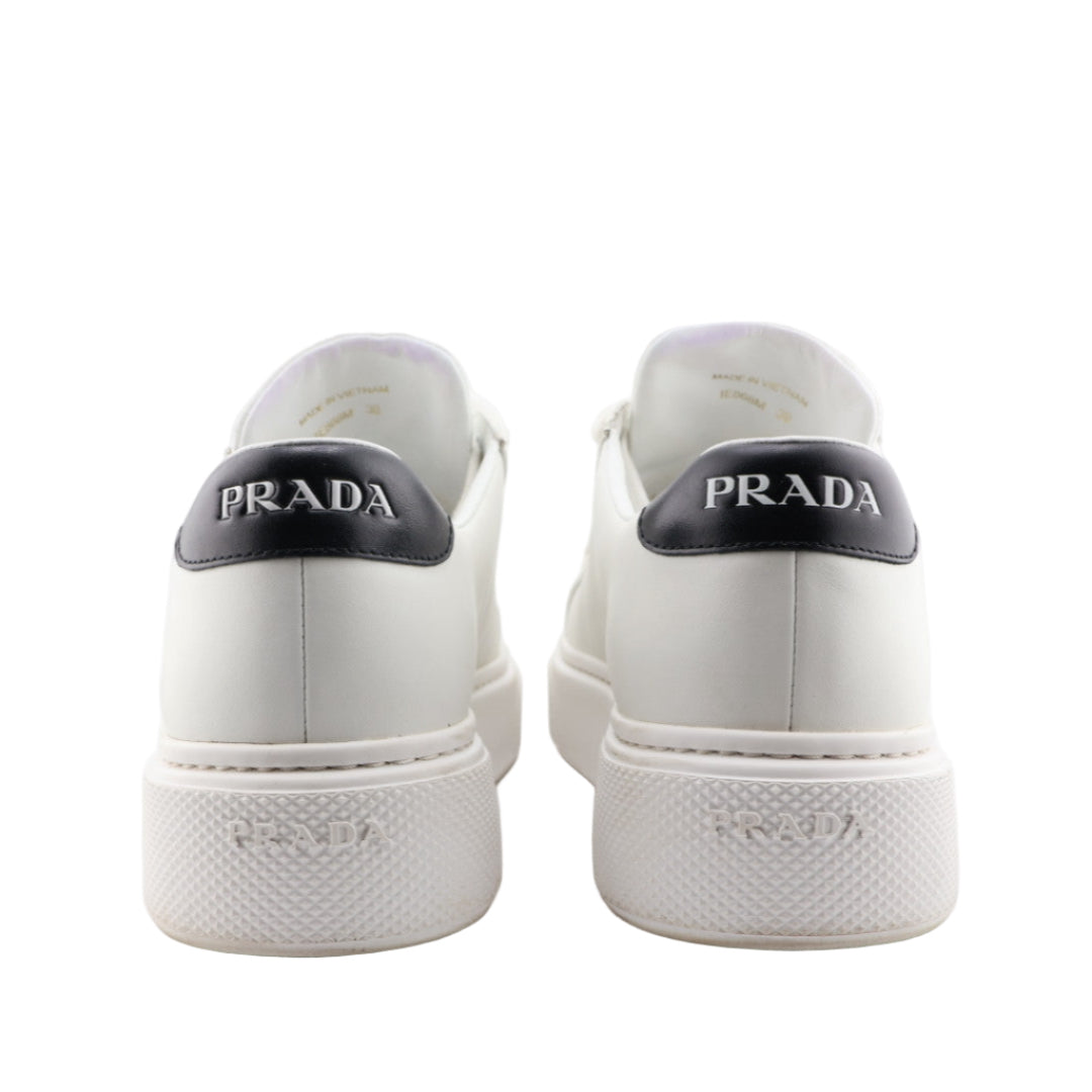 White Prada sneakers with black logo on a white background