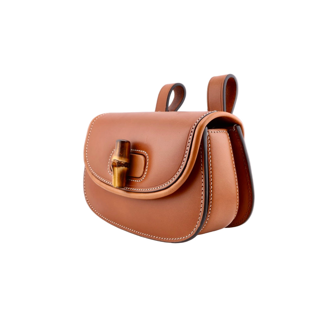 Brown leather handbag with gold hardware on a white background