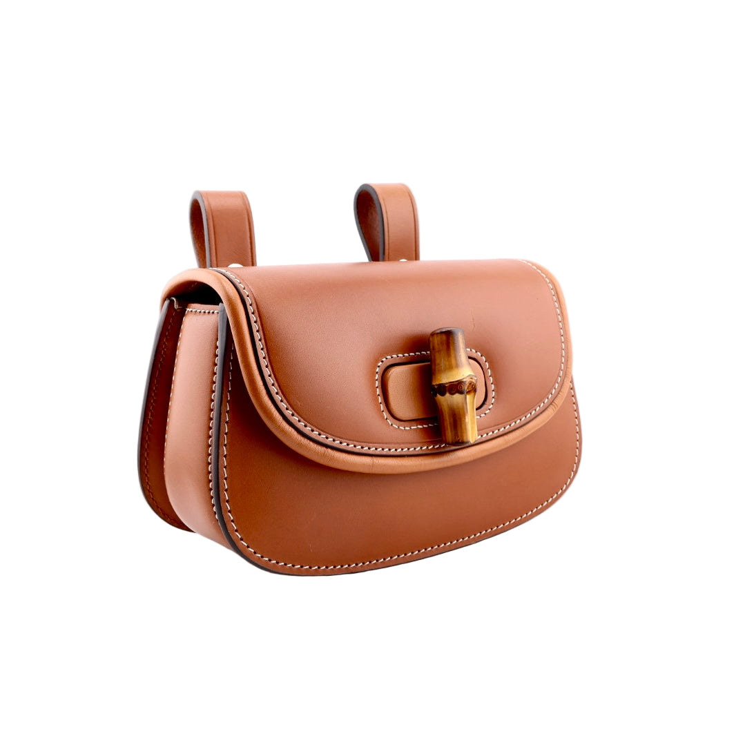 Brown leather handbag with gold buckle on a white background