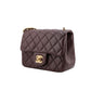 Quilted brown handbag with gold hardware on a white background