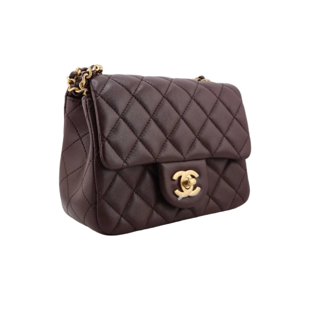 Quilted brown handbag with gold hardware on a white background