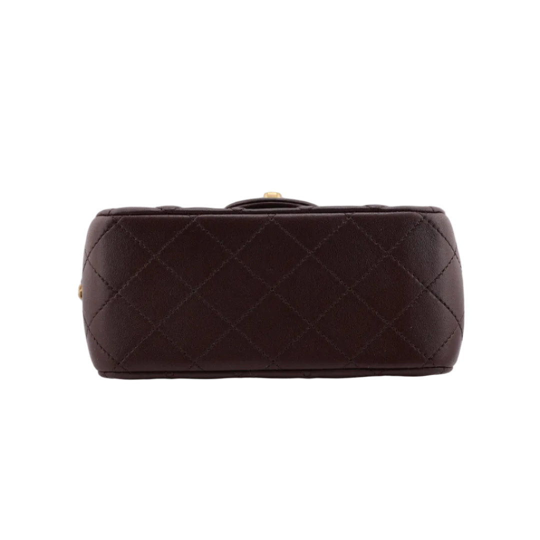 Brown quilted handbag on a white background
