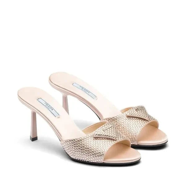 Pair of gold high-heeled sandals on a white background