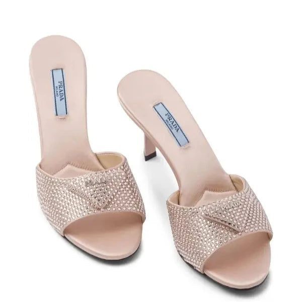 Pair of high-heeled shoes with rhinestone details on a white background