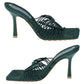 Pair of green high-heeled shoes with woven design on a white background