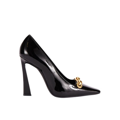 Black high-heeled shoe with a gold emblem on a light gray background