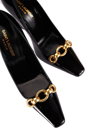 Black high-heeled shoes with gold chain details and 'Saint Laurent' branding on a light gray background.