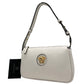 White handbag with gold emblem and Versace tag on a white background