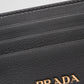 Black Prada Milano wallet with gold logo on a light gray background