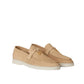 Pair of beige loafers on a light beige background