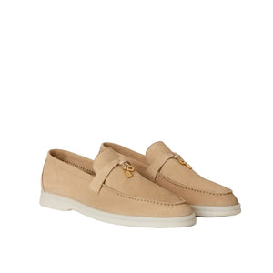 Pair of beige loafers on a light beige background