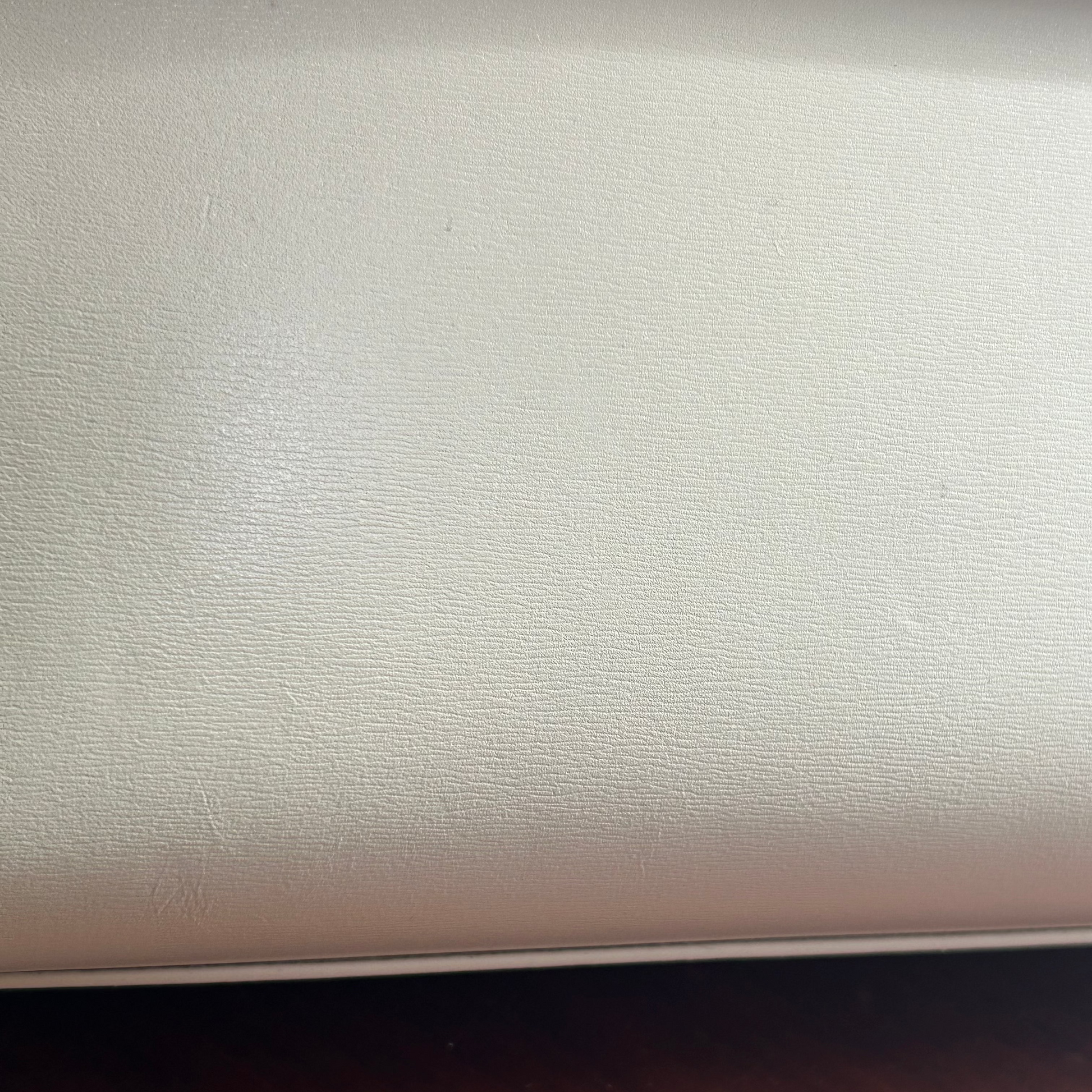 Close-up of a beige leather surface on a wooden floor