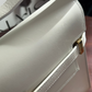 Close-up of a beige handbag with gold accents