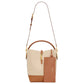 Two-tone beige and brown handbag with gold hardware on a white background