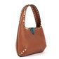 Brown leather handbag with studded details on a white background
