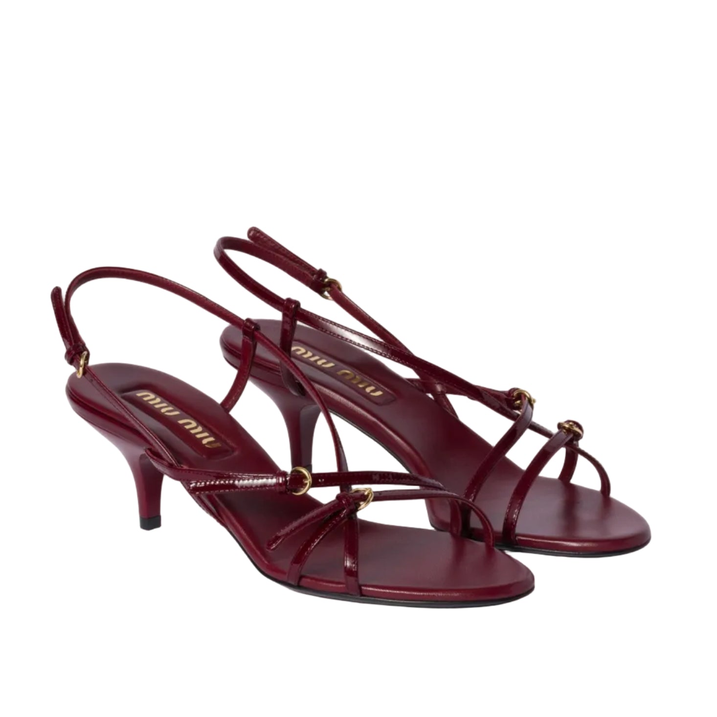 Pair of burgundy high-heeled sandals on a light beige background
