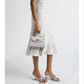Woman wearing a pearl grey gold Versace dress on a white background