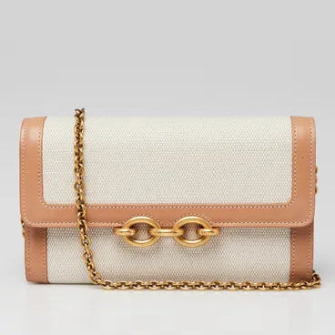 Handbag with beige leather and gold chain on a light gray background