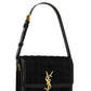 Black quilted handbag with gold logo on a white background