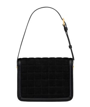 Black quilted handbag with a strap on a white background