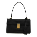 A black leather handbag with a structured rectangular shape, a single top handle, a front flap, and a gold-tone lock closure. A black leather tag hangs from the side, and the bag is photographed against a plain white background.