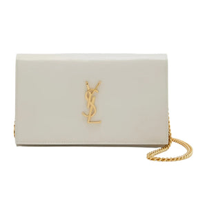 White YSL handbag with gold chain and logo on a light gray background