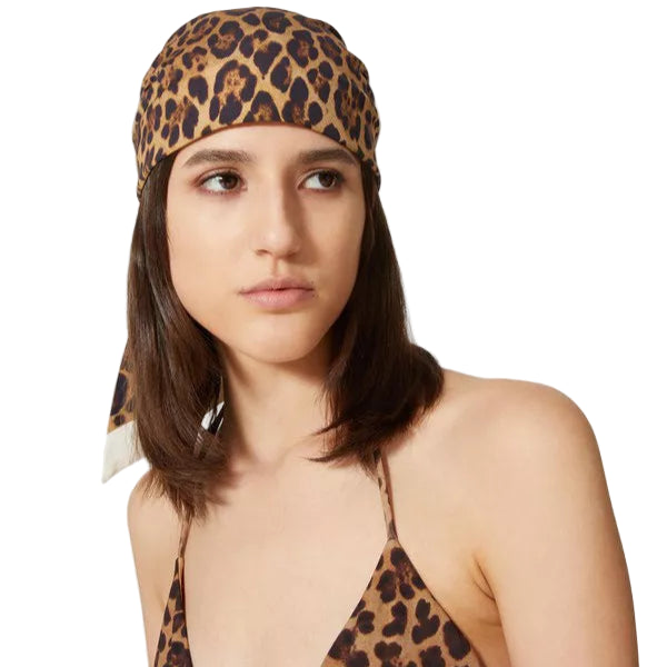Woman wearing a leopard print headscarf and bikini top on a white background